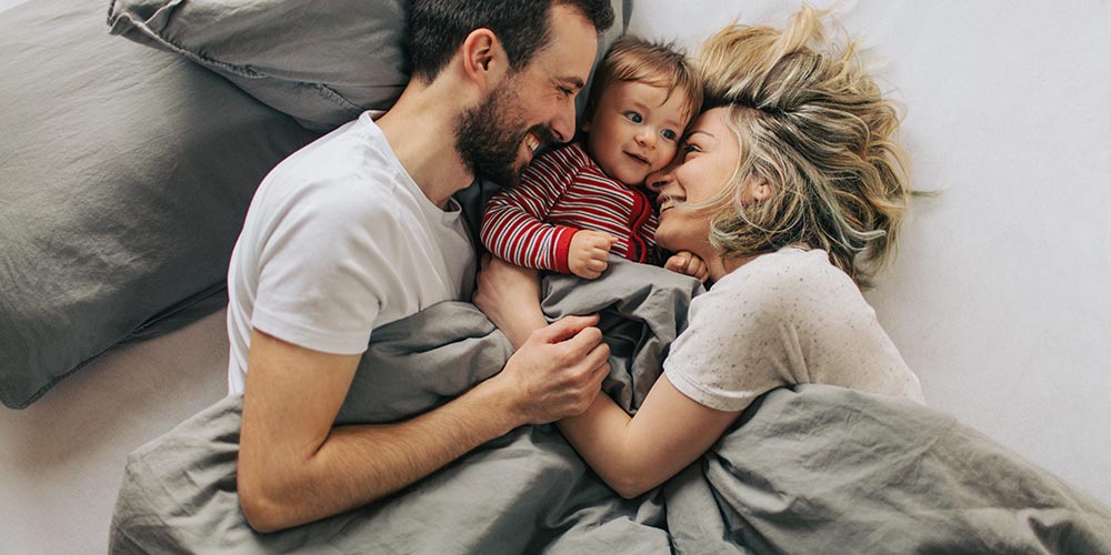 Mutter und Vater umarmen ihr Kind